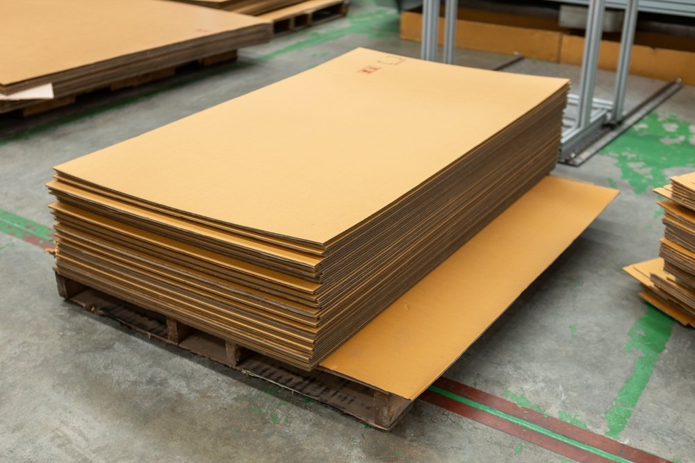 Stacked sheets of raw corrugated board